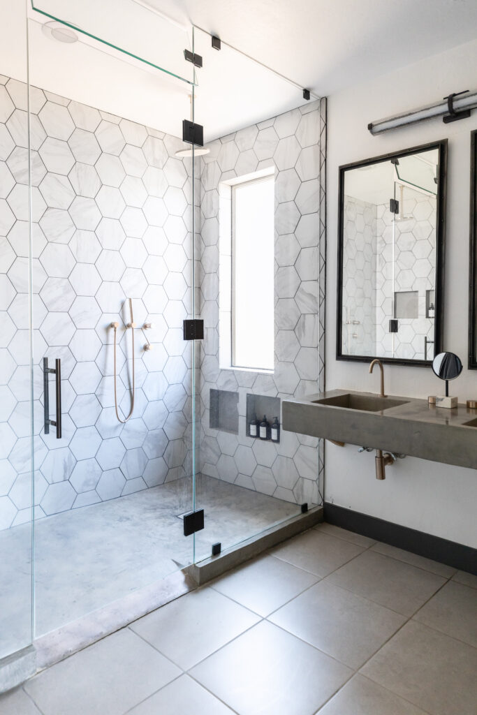 Accessible bathroom with curb less walk-in shower, hexagon tile walls, and floating sink. ADA Design