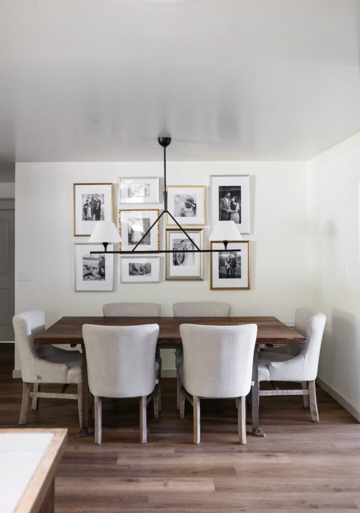 Accessible dining room with a 30-inch barrier-free wooden table, upholstered chairs for comfort, and a gallery wall of black-and-white photos.