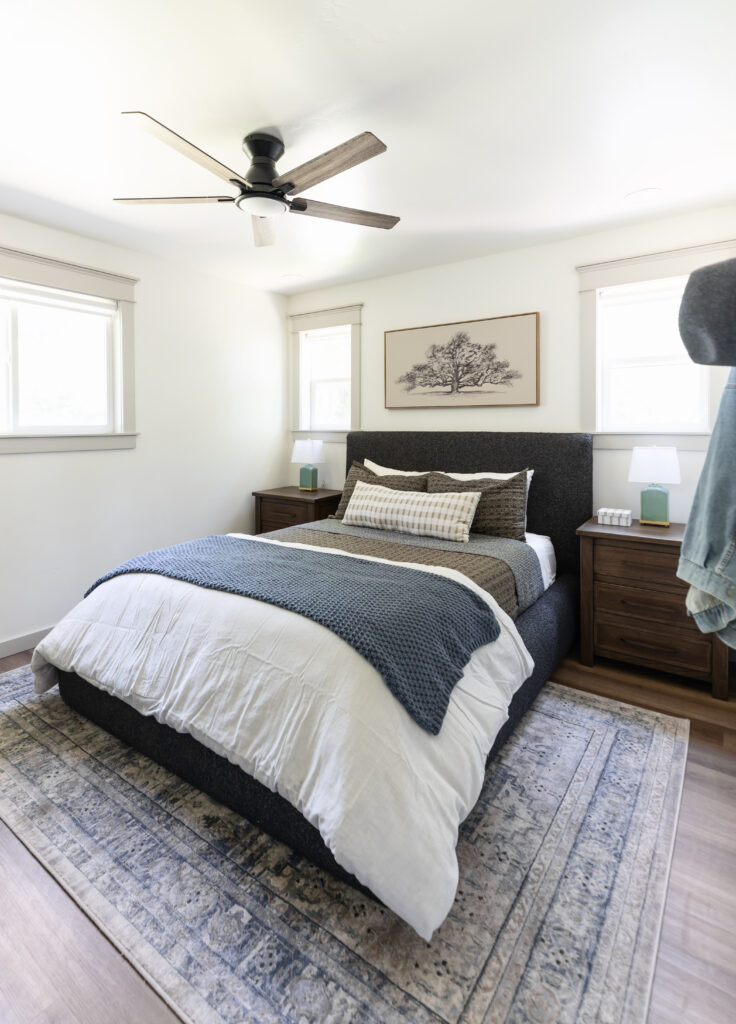 Accessible bedroom with a barrier-free bed at ideal transfer height, matching wooden nightstands, and layered bedding in neutral tones.