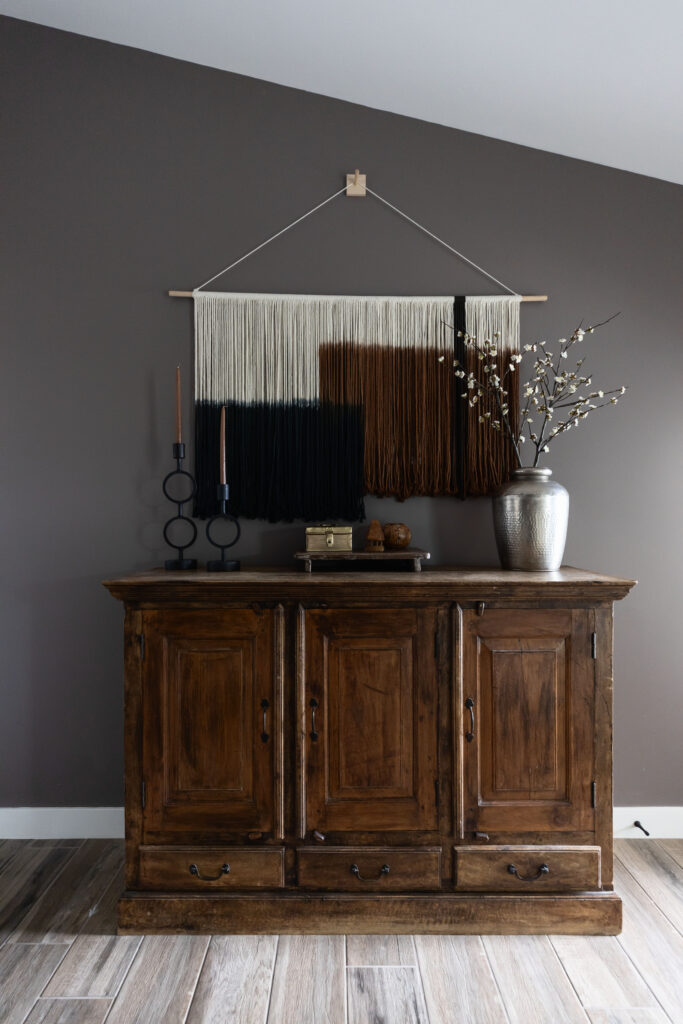 Southwest-inspired living room vignette featuring rustic wood sideboard, textile wall art, and ceramic accents.