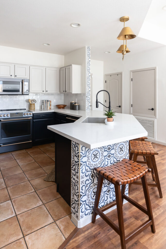 Eclectic Arizona kitchen with custom tile island, brass lighting, and natural woven seating accents.