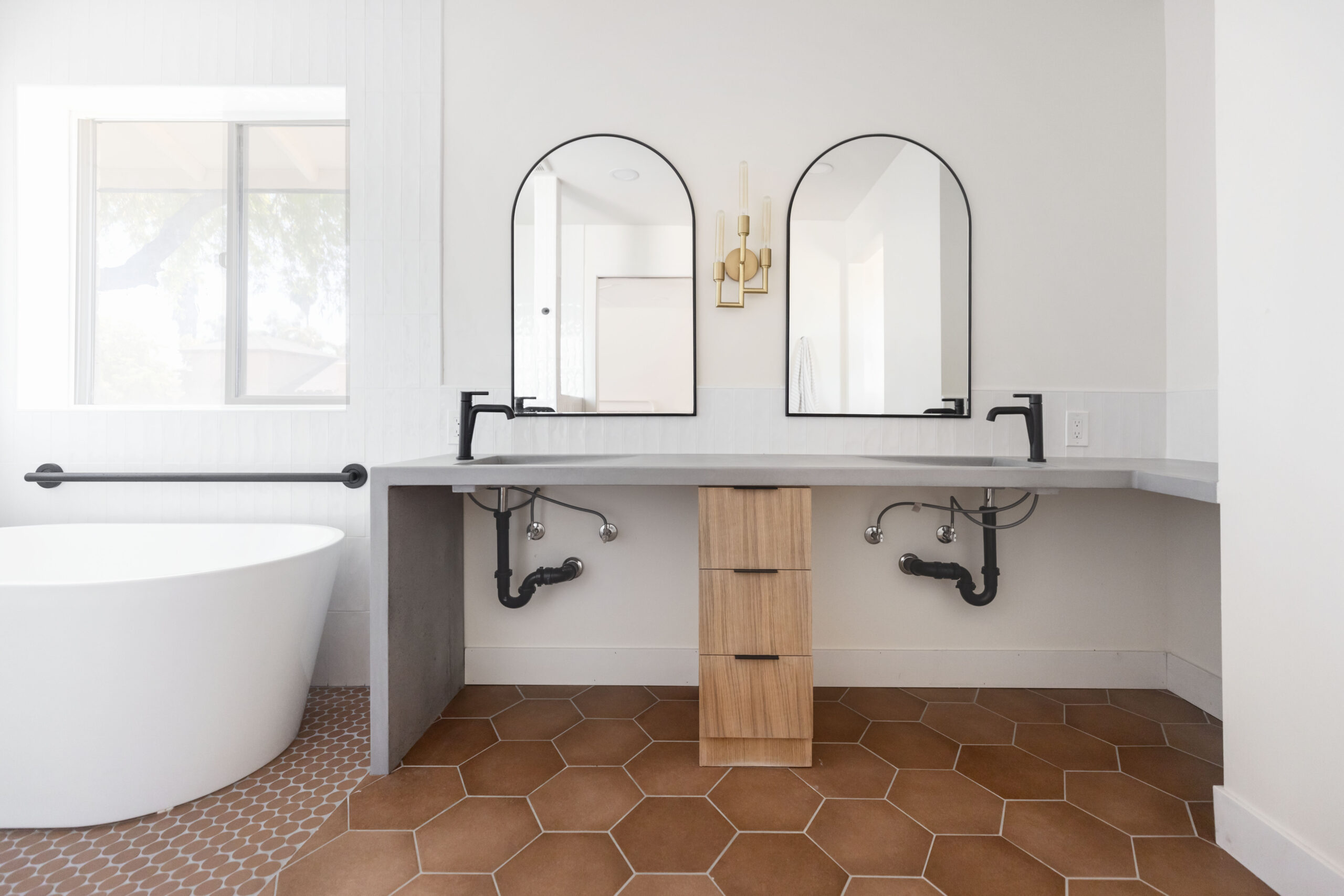 Barrier free bathroom with roll under sink, concrete countertops, and terracotta hexagon tile floors.