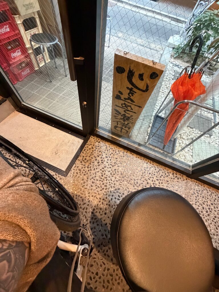 Wheelchair user teetering on the edge of a step in a ramen shop in Japan because the restaurant was not wheelchair accessible
